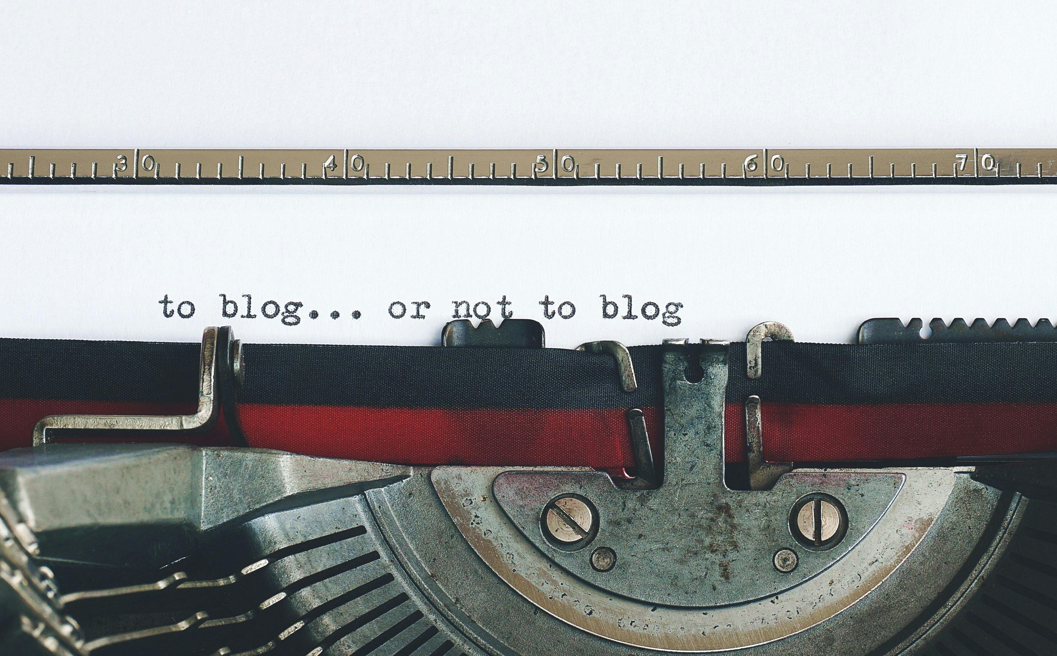 eine Schreibmaschine schreibt einen Blog auf ein Blatt Papier